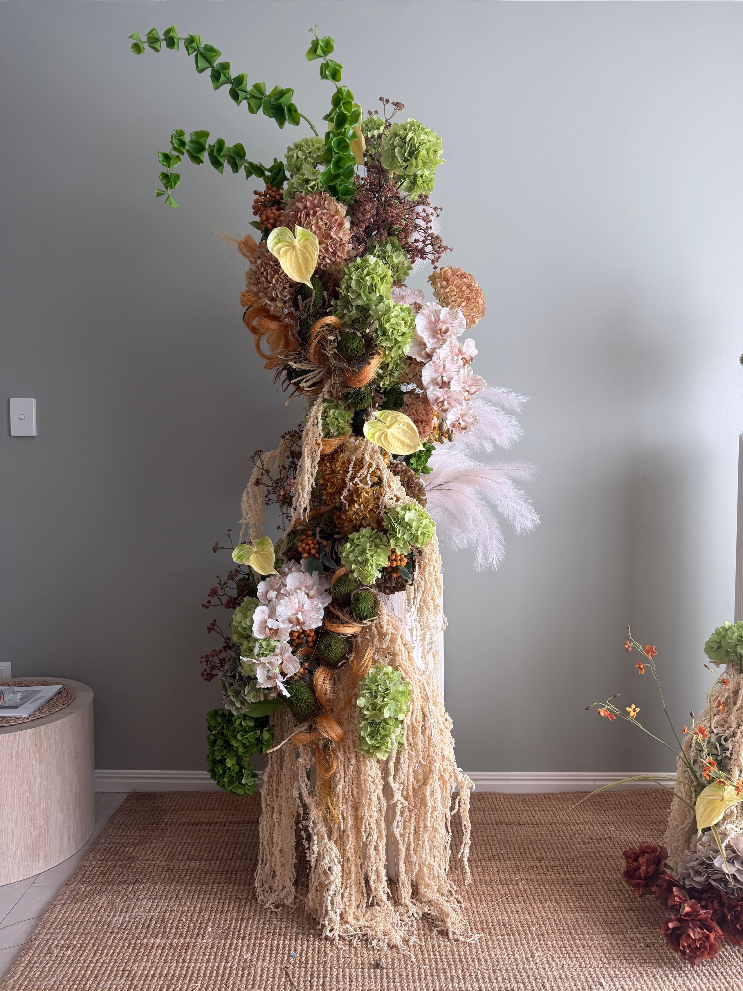 Anthurium, hydrangea and dried textures in a sculptural floral column