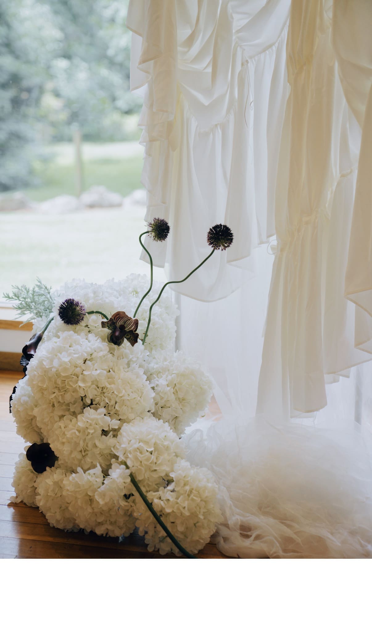 Close-up of The Sculpture's shorter white floral arrangement and soft fabric draping