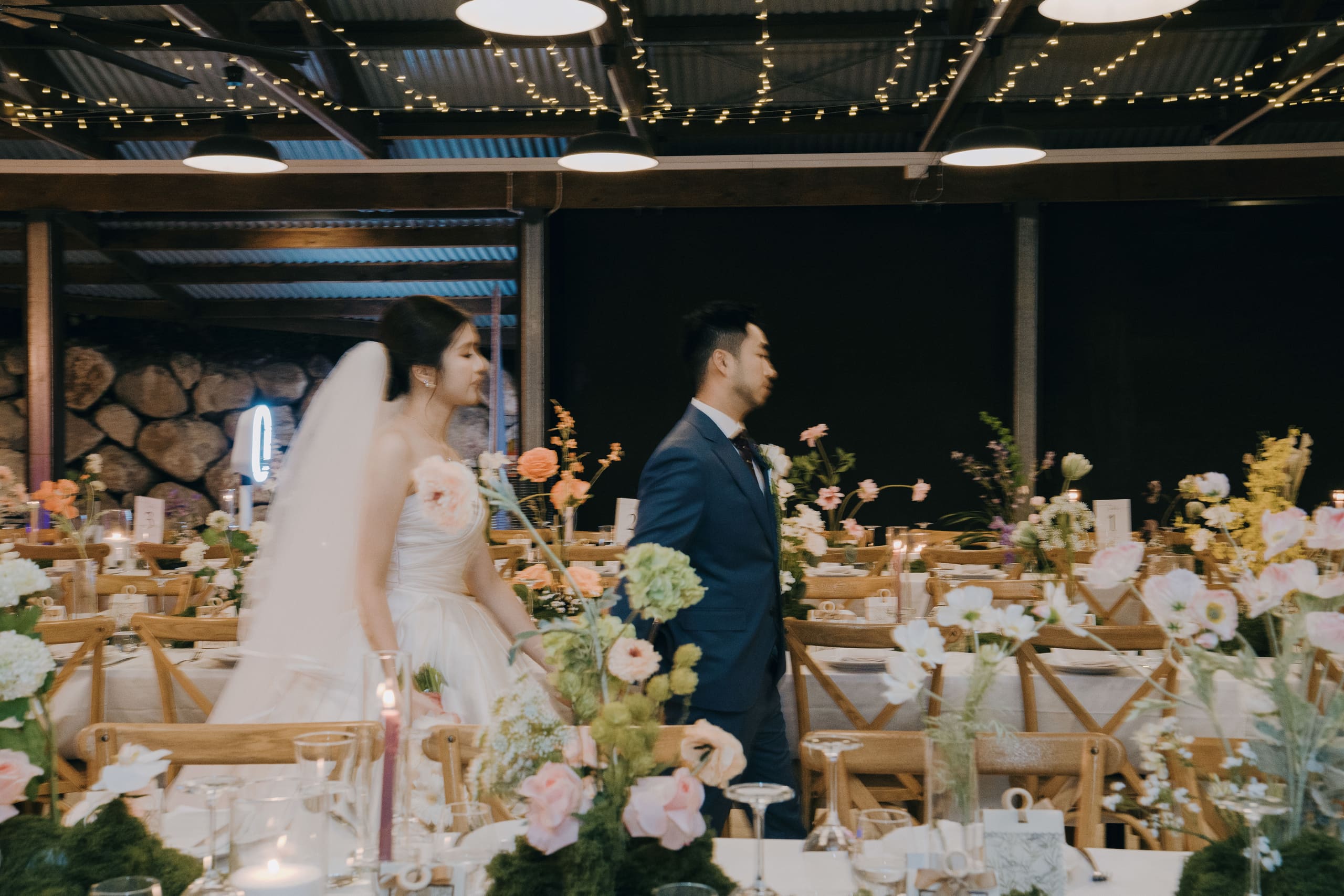 A groom walking past floral-laden reception tables