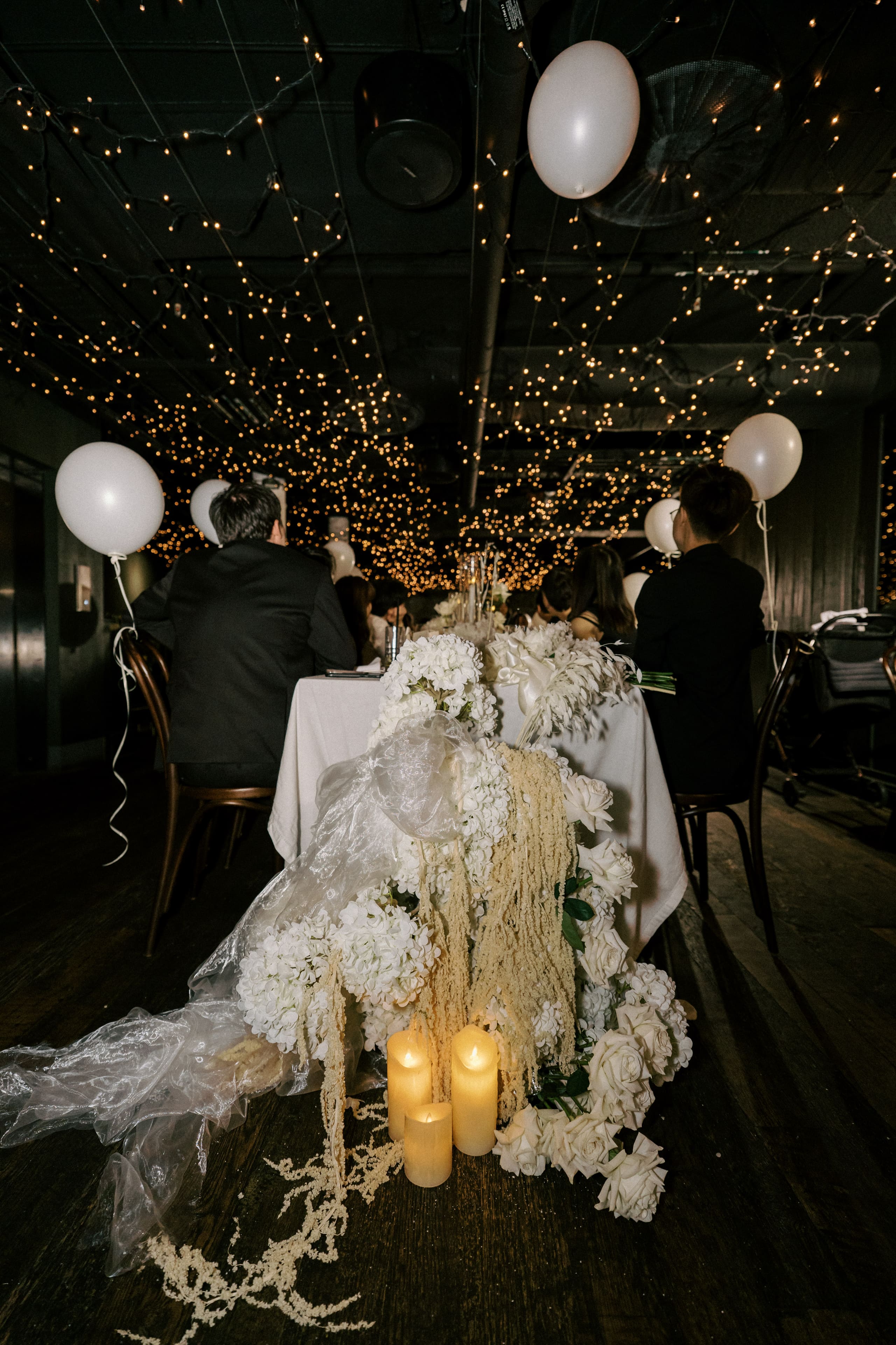 White florals, trailing amaranthus and candlelight at a reception table