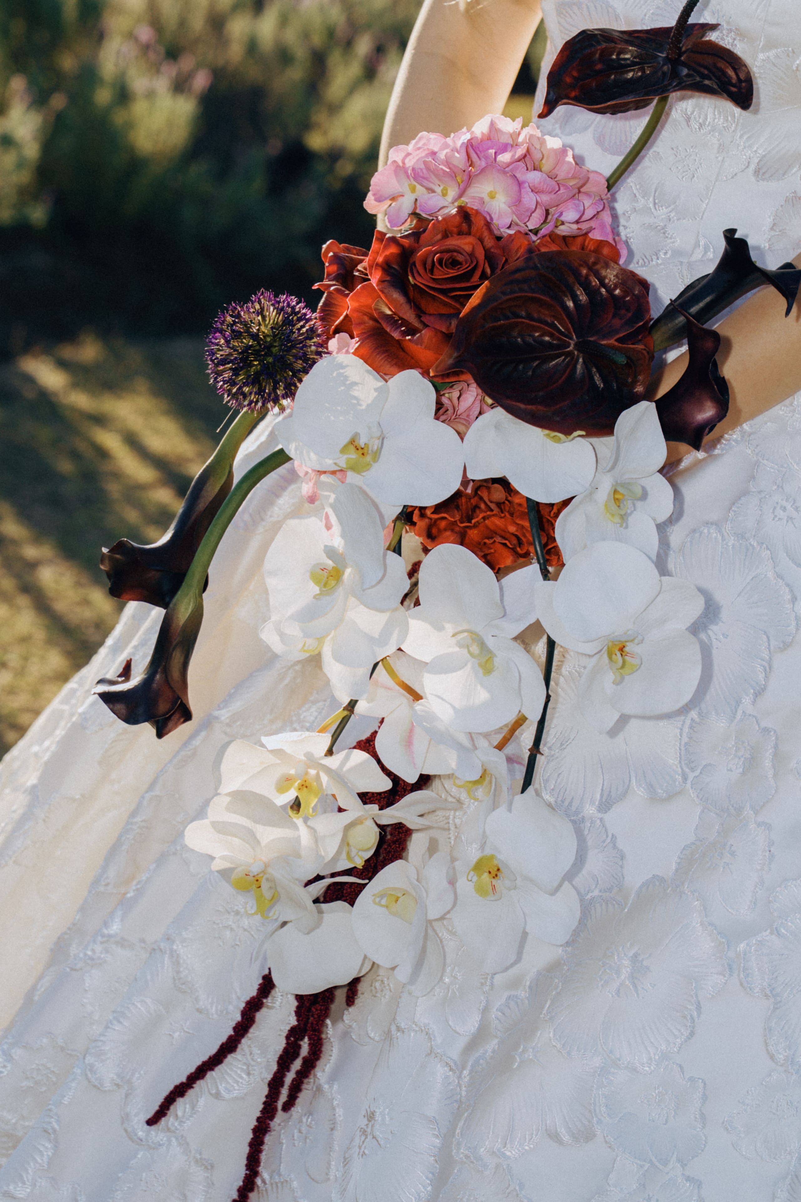 A bridal bouquet of white orchids and deep red blooms