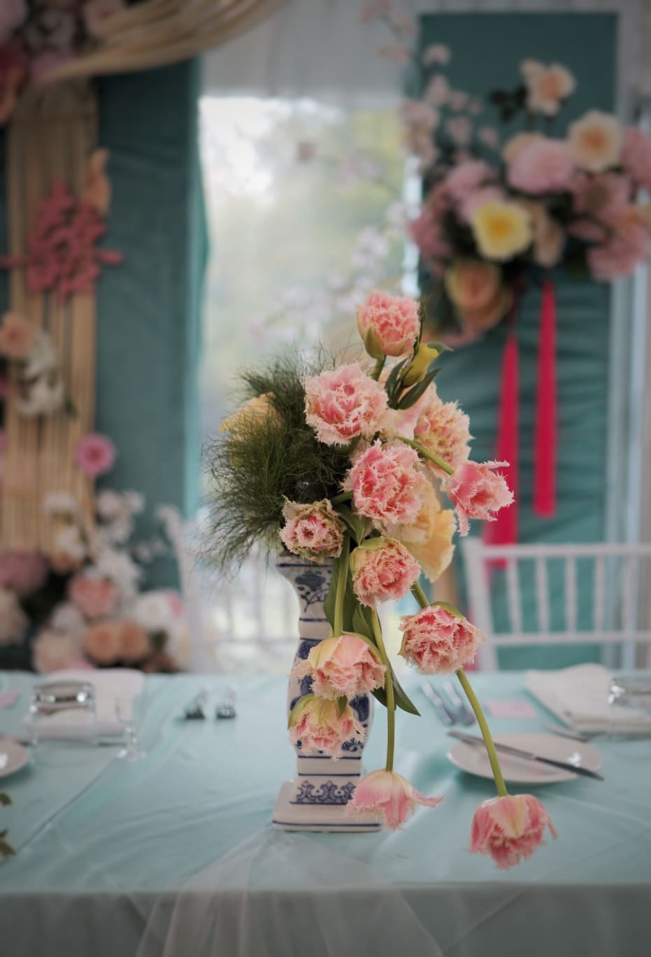 Pink roses and teal details on a reception table