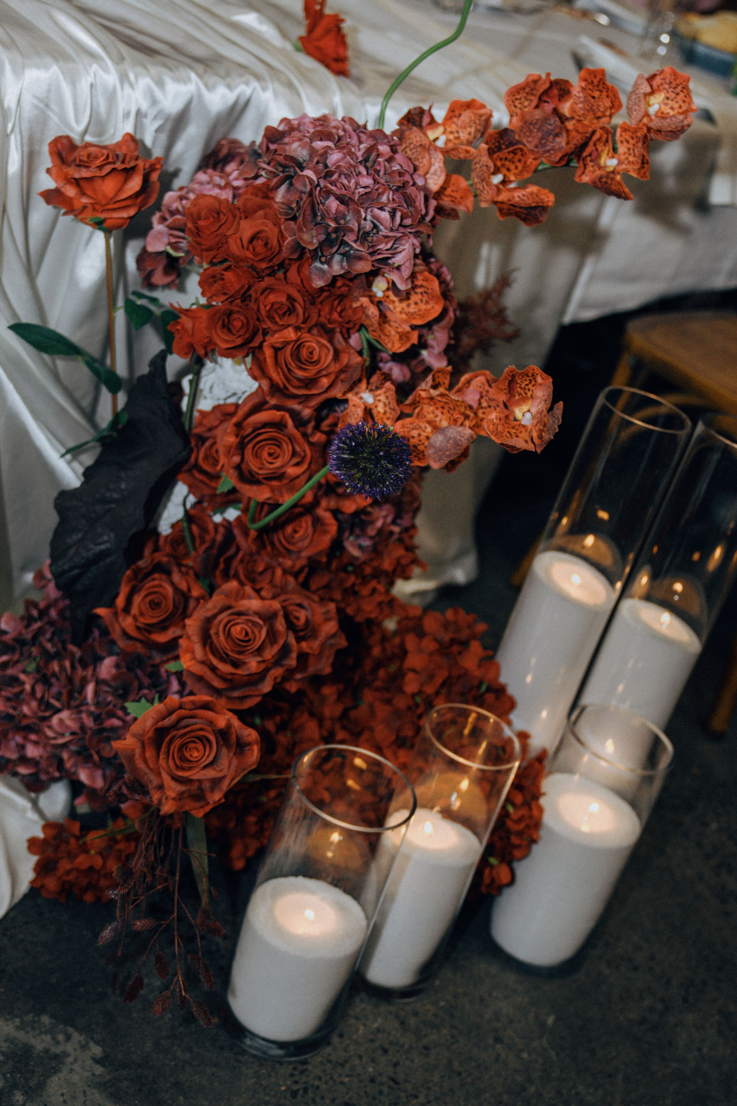 Red and plum floral arrangement with pillar candles